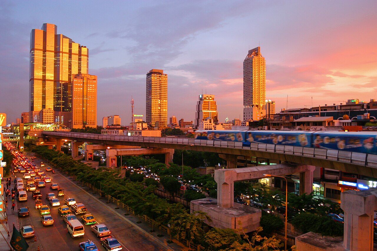 BTS Skytrain de Bangkok ante edificios altos al atardecer