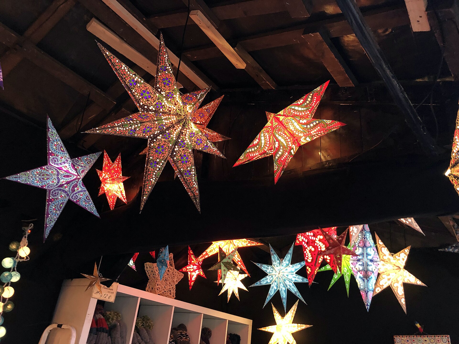 Colourful illuminated star lanterns at a Berlin Christmas market stall