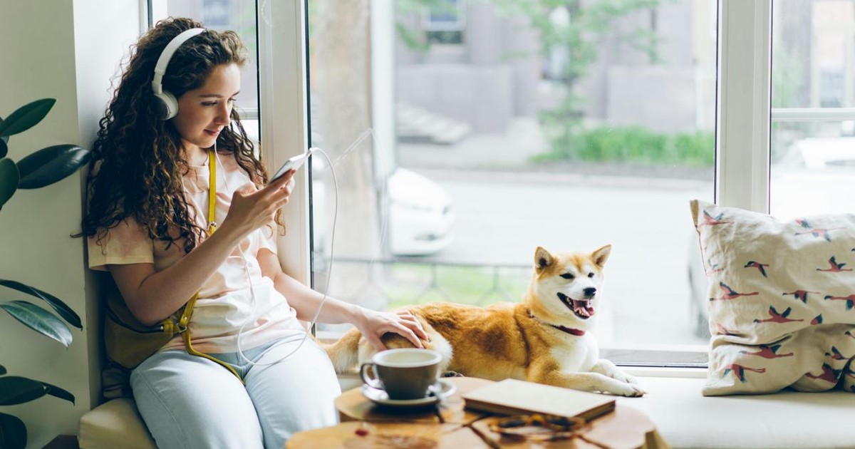 How much data does streaming use, shown by a traveler watching video on a smartphone in a cafe