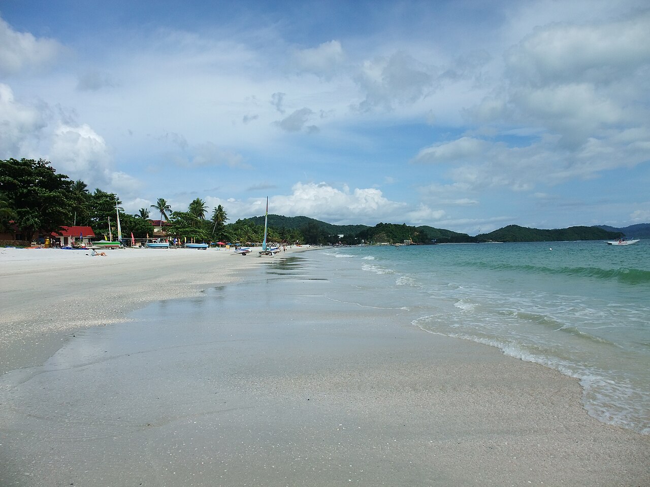 Pale sand, small boats and calm water at Pantai Cenang, Langkawi