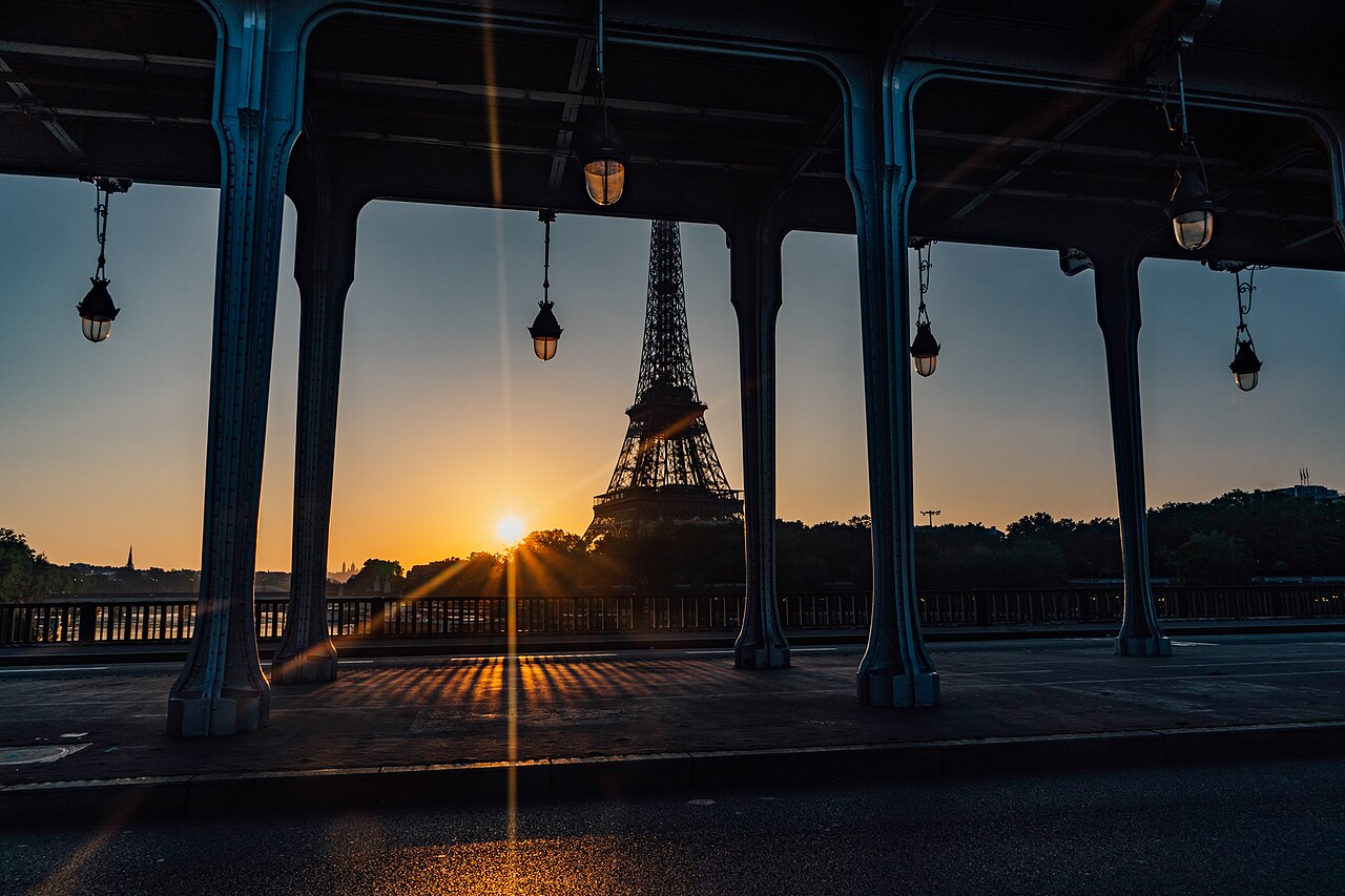 Eiffel Tower at sunrise framed by the arches of Pont de Bir-Hakeim