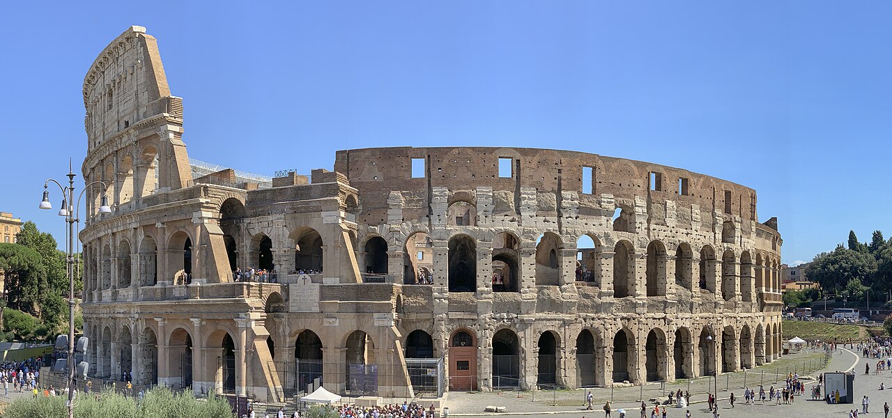 The outer arches of Rome’s Colosseum under a blue sky